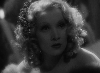 Movie still from “The Scarlet Empress” (1934), directed by Josef von Sternberg – A black and white photo of a woman with curly hair; Close Up shot, Over the shoulder angle
