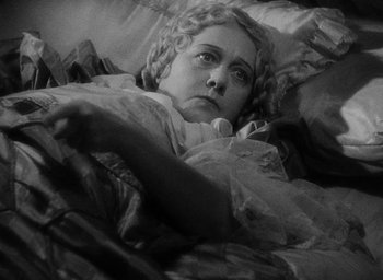 Movie still from “The Scarlet Empress” (1934), directed by Josef von Sternberg – A woman laying in a bed with her head on a pillow; Close Up shot, High angle