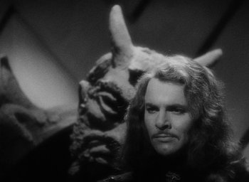 Movie still from “The Scarlet Empress” (1934), directed by Josef von Sternberg – A black and white photo of a man and a monster; Close Up shot, Over the shoulder angle