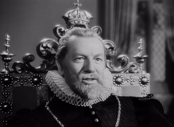 Movie still from “The Sea Hawk” (1940), directed by Michael Curtiz – An older man with a beard wearing a crown; Close Up shot, Low angle