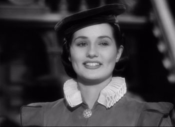 Movie still from “The Sea Hawk” (1940), directed by Michael Curtiz – A woman wearing a hat and smiling for the camera; Close Up shot, Low angle
