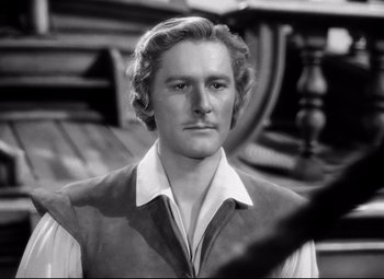 Movie still from “The Sea Hawk” (1940), directed by Michael Curtiz – A black - and - white photo of a man with long blonde hair; Close Up shot, Over the shoulder angle