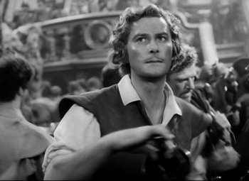 Movie still from “The Sea Hawk” (1940), directed by Michael Curtiz – Black and white photograph of a man in a crowd of people; Close Up shot, High angle