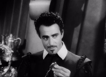 Movie still from “The Sea Hawk” (1940), directed by Michael Curtiz – Black and white photograph of a man in a suit and tie; Close Up shot, Over the shoulder angle