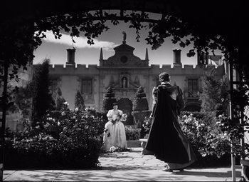 Movie still from “The Sea Hawk” (1940), directed by Michael Curtiz – A man and a woman are standing in front of a castle; Extreme Wide shot, Low angle