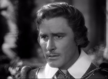 Movie still from “The Sea Hawk” (1940), directed by Michael Curtiz – Black and white photograph of a man in a suit and tie; Close Up shot, High angle