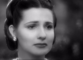 Movie still from “The Sea Hawk” (1940), directed by Michael Curtiz – An old photo of a beautiful woman with dark hair; Close Up shot, High angle