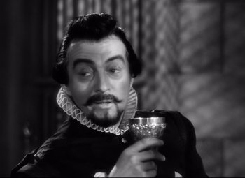 Movie still from “The Sea Hawk” (1940), directed by Michael Curtiz – A man with a beard holding a wine glass; Close Up shot, Low angle