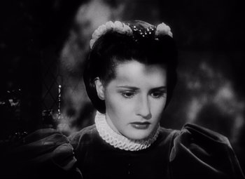 Movie still from “The Sea Hawk” (1940), directed by Michael Curtiz – A black and white photo of a woman in a dress; Close Up shot, High angle