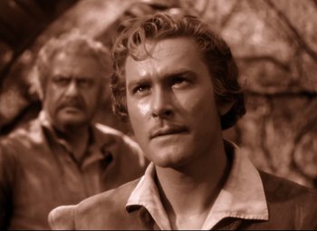 Movie still from “The Sea Hawk” (1940), directed by Michael Curtiz – A man with a beard and mustache and a man with long hair and goatee; Close Up shot, Low angle