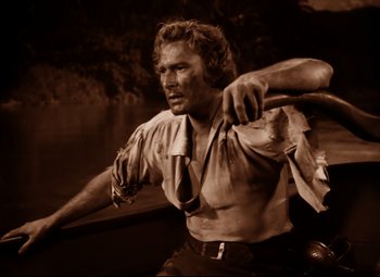 Movie still from “The Sea Hawk” (1940), directed by Michael Curtiz – A black and white photo of a man holding a tie; Medium shot, High angle