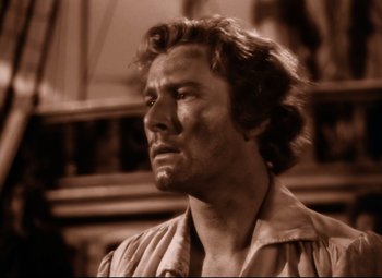 Movie still from “The Sea Hawk” (1940), directed by Michael Curtiz – A man in a brown shirt is looking to his left; Close Up shot, Over the shoulder angle