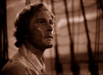Movie still from “The Sea Hawk” (1940), directed by Michael Curtiz – A black and white photo of a man looking to his left; Close Up shot, Low angle