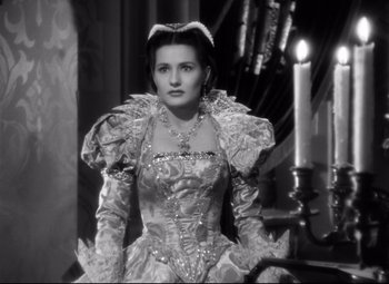 Movie still from “The Sea Hawk” (1940), directed by Michael Curtiz – A black and white photo of a woman in a dress; Medium shot, Low angle