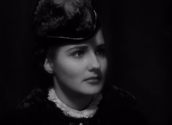 Movie still from “The Sea Hawk” (1940), directed by Michael Curtiz – A black and white photo of a woman wearing a hat; Close Up shot, High angle