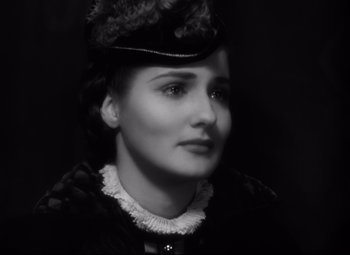 Movie still from “The Sea Hawk” (1940), directed by Michael Curtiz – An old photo of a woman wearing a hat; Close Up shot, High angle
