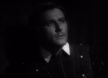 Movie still from “The Sea Hawk” (1940), directed by Michael Curtiz – A black and white photo of a man looking at the camera; Close Up shot, Low angle