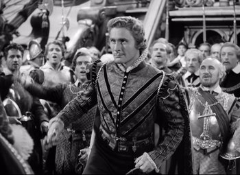 Movie still from “The Sea Hawk” (1940), directed by Michael Curtiz – A group of men in medieval garb in front of a crowd of onlookers; Medium shot, Low angle
