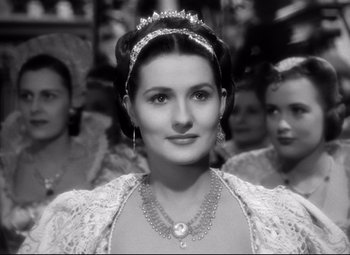 Movie still from “The Sea Hawk” (1940), directed by Michael Curtiz – A black and white photo of a woman wearing a tiara; Close Up shot, Over the shoulder angle