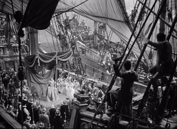 Movie still from “The Sea Hawk” (1940), directed by Michael Curtiz – A crowd of people standing on top of a boat; Extreme Wide shot, High angle