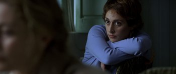 Movie still from “The Sea Inside” (2004), directed by Alejandro Amenábar – A woman sitting on a chair with her arms crossed; Close Up shot, Over the shoulder angle