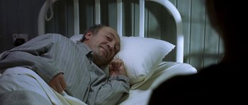 Movie still from “The Sea Inside” (2004), directed by Alejandro Amenábar – A man laying in a bed with a pillow; Medium shot, High angle
