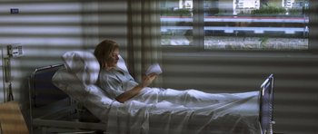 Movie still from “The Sea Inside” (2004), directed by Alejandro Amenábar – A woman sitting in a hospital bed reading a book; Wide shot, High angle