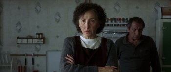 Movie still from “The Sea Inside” (2004), directed by Alejandro Amenábar – An older woman standing with her arms crossed in a kitchen; Close Up shot, Low angle