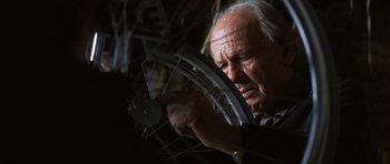Movie still from “The Sea Inside” (2004), directed by Alejandro Amenábar – An older man looking at a clock on the side of a bicycle; Close Up shot, Low angle