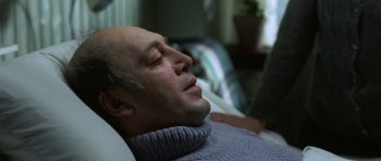 Movie still from “The Sea Inside” (2004), directed by Alejandro Amenábar – An older man laying in bed with his eyes closed; Close Up shot, High angle