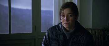 Movie still from “The Sea Inside” (2004), directed by Alejandro Amenábar – A woman in a black jacket is looking sad; Close Up shot, Over the shoulder angle