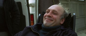 Movie still from “The Sea Inside” (2004), directed by Alejandro Amenábar – A man smiling while sitting in a wheelchair; Close Up shot, Low angle