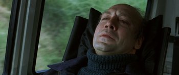 Movie still from “The Sea Inside” (2004), directed by Alejandro Amenábar – A bald man with his eyes closed and his head resting on his arm; Close Up shot, High angle