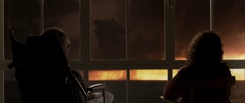 Movie still from “The Sea Inside” (2004), directed by Alejandro Amenábar – A view of a sunset through a window with a chair; Medium shot, Over the shoulder angle