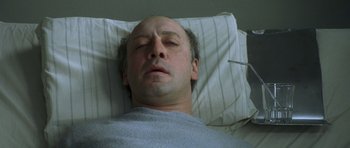 Movie still from “The Sea Inside” (2004), directed by Alejandro Amenábar – A man laying in a hospital bed with his eyes closed; Close Up shot, Overhead angle