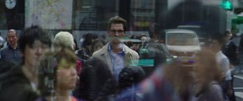 Movie still from “The Sea of Trees” (2015), directed by Gus Van Sant – A man with glasses and a beard in a crowd of people; Medium shot, Over the shoulder angle