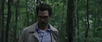 Movie still from “The Sea of Trees” (2015), directed by Gus Van Sant – A person wearing glasses and a jacket; Close Up shot, Low angle