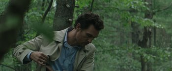 Movie still from “The Sea of Trees” (2015), directed by Gus Van Sant – A person leaning against a tree; Medium shot, Low angle