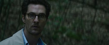 Movie still from “The Sea of Trees” (2015), directed by Gus Van Sant – A person wearing glasses in a forest; Close Up shot, Over the shoulder angle