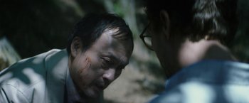 Movie still from “The Sea of Trees” (2015), directed by Gus Van Sant – A man with blood on his face is looking at another man with blood all over his face; Close Up shot, Over the shoulder angle