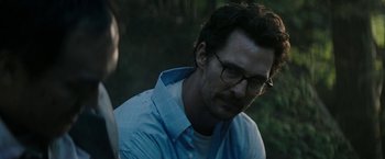 Movie still from “The Sea of Trees” (2015), directed by Gus Van Sant – A person wearing glasses and a blue shirt; Close Up shot, Over the shoulder angle