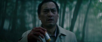 Movie still from “The Sea of Trees” (2015), directed by Gus Van Sant – A man holding a bottle of medicine in his hand; Close Up shot, Low angle