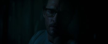 Movie still from “The Sea of Trees” (2015), directed by Gus Van Sant – A person wearing glasses in the dark; Close Up shot, Low angle