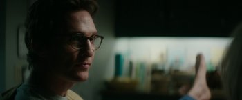 Movie still from “The Sea of Trees” (2015), directed by Gus Van Sant – A person wearing glasses and a yellow shirt; Close Up shot, Over the shoulder angle