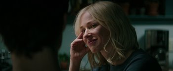 Movie still from “The Sea of Trees” (2015), directed by Gus Van Sant – A woman with blonde hair is smiling and holding her hand to her face; Close Up shot, Over the shoulder angle