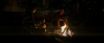 Movie still from “The Sea of Trees” (2015), directed by Gus Van Sant – Two people sitting around a fire in the dark; Medium shot, Over the shoulder angle