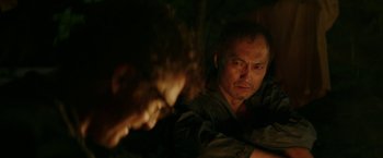 Movie still from “The Sea of Trees” (2015), directed by Gus Van Sant – A man in a dark room looking at the camera; Close Up shot, Over the shoulder angle