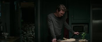 Movie still from “The Sea of Trees” (2015), directed by Gus Van Sant – A man standing in front of a wooden table; Medium shot, Over the shoulder angle