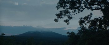 Movie still from “The Sea of Trees” (2015), directed by Gus Van Sant – A view of a mountain with a tree in the foreground; Extreme Wide shot, Low angle