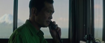 Movie still from “The Sea of Trees” (2015), directed by Gus Van Sant – A man talking on a phone in front of a window; Close Up shot, Low angle